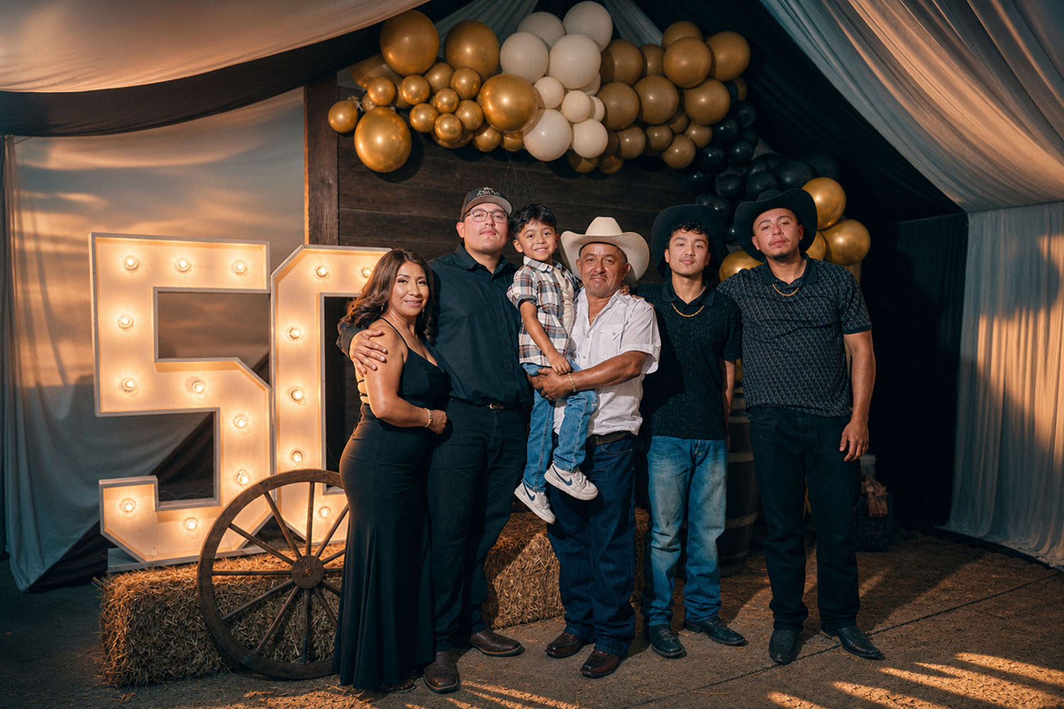 Family portrait at 50th birthday celebration with marquee lights